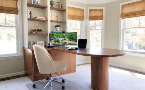Home office with walnut oval desk and bay window