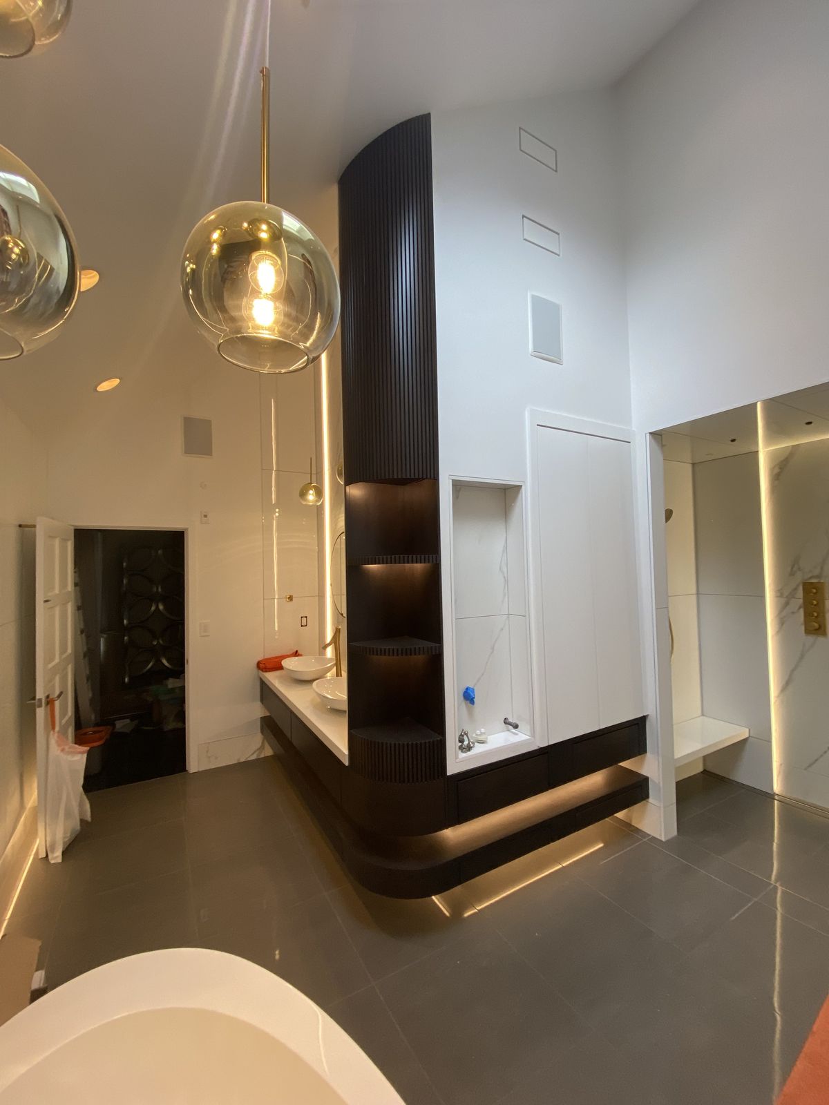 Luxury bath with curved fluted partition and freestanding tub