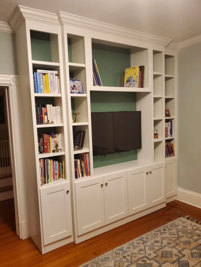 White bookcase with green back panel and TV