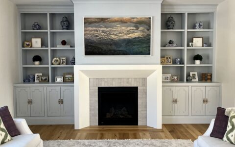 White built-ins flanking fireplace with artwork