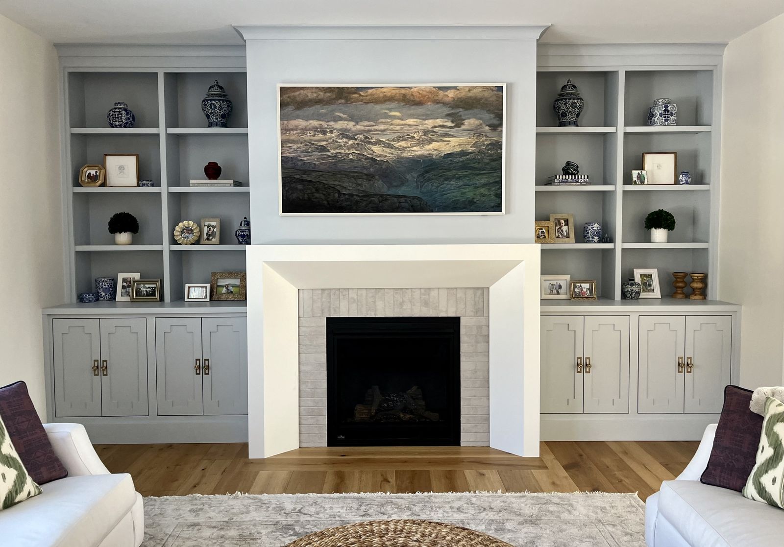 White built-ins flanking fireplace with artwork